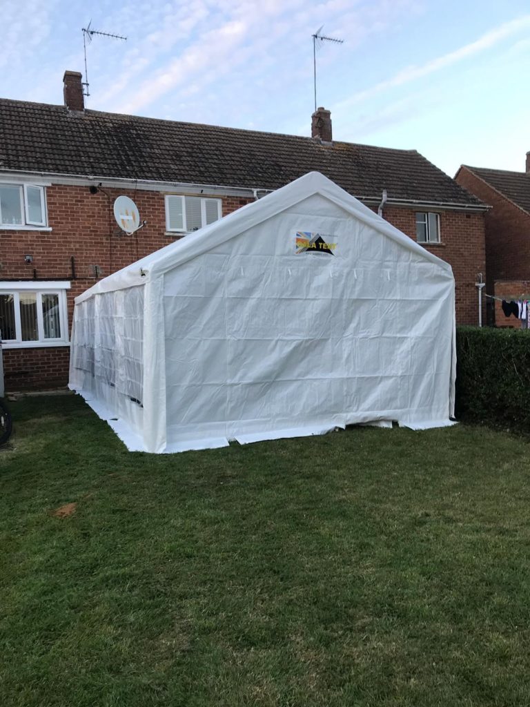 4m-x-6m-tent-being-setup-against-their-patio-doors