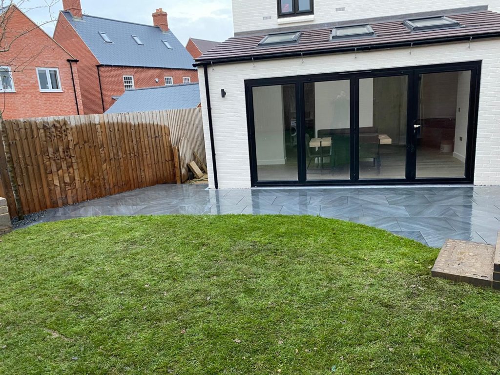 Brand new turf laid up to porcelain patio