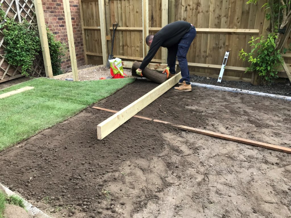 Turf being laid within mowing edging